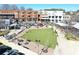 Aerial view of a vibrant town square featuring green spaces, seating areas, and surrounding commercial buildings at 5760 Palmtree Pass, Cumming, GA 30040