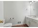 White half bath featuring a toilet, vanity, mirror, and dark wood floors at 1440 Sandford Sw Trl, Lilburn, GA 30047