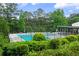 Community pool surrounded by lush greenery, lounge chairs, and covered area at 1440 Sandford Sw Trl, Lilburn, GA 30047