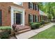 Close-up of a beautiful brick home's entrance with a stylish black door and decorative plants at 1440 Sandford Sw Trl, Lilburn, GA 30047