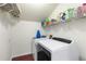 Well-organized laundry room with washer, dryer, shelves, and laundry supplies at 1440 Sandford Sw Trl, Lilburn, GA 30047