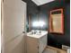 Bathroom with bold black walls, a vanity and a framed mirror at 2004 Poplar Falls Rd, Lithonia, GA 30058