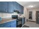 Traditional kitchen with blue cabinets, tile floors, and modern appliances at 2004 Poplar Falls Rd, Lithonia, GA 30058