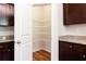 Convenient pantry with shelving, located next to a kitchen with granite countertops and dark wood cabinets at 2352 Allman Dr, Jonesboro, GA 30236