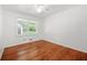 Bright bedroom features hardwood floors, a ceiling fan, and a window with view of lush greenery at 3050 Rebecca Sw Dr, Atlanta, GA 30311