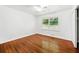Bright bedroom with hardwood floors, ceiling fan and a large window looking out into the yard at 3050 Rebecca Sw Dr, Atlanta, GA 30311