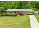 Charming red brick home with green shutters and a well-manicured lawn, offering great curb appeal at 3050 Rebecca Sw Dr, Atlanta, GA 30311