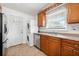 Kitchen featuring stainless steel appliances, wood cabinets, and adjacent washer/dryer for added convenience at 3050 Rebecca Sw Dr, Atlanta, GA 30311