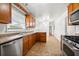 Well-lit kitchen with stainless appliances, ample counter space, wood cabinets, and vinyl flooring at 3050 Rebecca Sw Dr, Atlanta, GA 30311