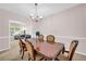 Charming dining room with a wooden table, chandelier, and a view into the living area at 3178 Arbor Oaks Way, Snellville, GA 30039