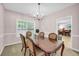 Elegant dining room with a chandelier, large table, and a view into another room at 3178 Arbor Oaks Way, Snellville, GA 30039
