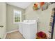 Organized laundry room with modern washer and dryer set and storage shelves at 3178 Arbor Oaks Way, Snellville, GA 30039