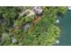 Breathtaking aerial view of a waterfront property surrounded by lush greenery and boat dock at 7830 Kings Point Dr, Cumming, GA 30041