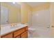 Traditional bathroom featuring a wood vanity, tub shower combination and patterned wallpaper at 7830 Kings Point Dr, Cumming, GA 30041