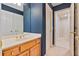 Bathroom featuring navy wallpaper, marble countertop, wood vanity and tile floors at 7830 Kings Point Dr, Cumming, GA 30041