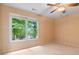 Cozy bedroom with large window offering wooded view, carpeted flooring, and ceiling fan at 7830 Kings Point Dr, Cumming, GA 30041