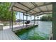 Covered dock with swing, boat slip, and lake views at 7830 Kings Point Dr, Cumming, GA 30041