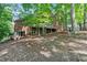 Brick home with a walkout basement and a spacious deck surrounded by lush greenery at 7830 Kings Point Dr, Cumming, GA 30041