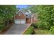 Charming two-story brick home with a well-manicured lawn and a two-car garage on a sunny day at 7830 Kings Point Dr, Cumming, GA 30041