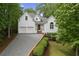 Charming white brick home featuring a two-car garage, and lush green landscaping at 7830 Kings Point Dr, Cumming, GA 30041
