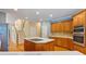 Spacious kitchen features a center island, stainless steel appliances, and access to a stairway at 7830 Kings Point Dr, Cumming, GA 30041