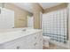 Well-lit bathroom featuring a vanity with white cabinets and a shower with a striped curtain at 1236 Brickton Nw Dr, Atlanta, GA 30318