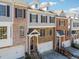 Exterior shot of townhomes showing brick and stone facade, two-car garages, and manicured landscaping at 1236 Brickton Nw Dr, Atlanta, GA 30318
