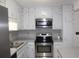 Well-lit kitchen featuring stainless steel appliances, white cabinets, and light countertops at 1457 Stoneleigh Cir, Stone Mountain, GA 30088