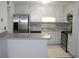White galley kitchen with stainless steel appliances, ample countertop space, and neutral backsplash at 1457 Stoneleigh Cir, Stone Mountain, GA 30088