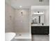 Bathroom featuring a walk-in shower, tub, and modern vanity at 1827 Shaker Falls Ln, Lawrenceville, GA 30045