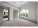 Bright bedroom with a vaulted ceiling, a ceiling fan, and a large window overlooking mature trees at 1827 Shaker Falls Ln, Lawrenceville, GA 30045