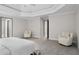 Main bedroom with a tray ceiling, carpet, and sitting area at 1827 Shaker Falls Ln, Lawrenceville, GA 30045