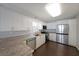 Modern kitchen with granite countertops, stainless steel appliances, and sleek white cabinetry at 2980 Porsche Nw Pl, Kennesaw, GA 30144