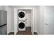 Convenient laundry area featuring a stacked washer and dryer unit next to a doorway at 2980 Porsche Nw Pl, Kennesaw, GA 30144