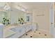 Bathroom featuring double sinks, white cabinets and light-colored tile flooring at 3003 W Roxboro Rd, Atlanta, GA 30324