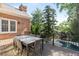 Exterior view of a deck with a dining table overlooking the pool and lush greenery at 3003 W Roxboro Rd, Atlanta, GA 30324