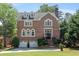 Elegant two-story brick home featuring a well-manicured lawn, classic architectural details, and a welcoming entrance at 3003 W Roxboro Rd, Atlanta, GA 30324