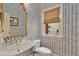 Stylish powder room featuring patterned wallpaper, a decorative mirror, and a window at 3003 W Roxboro Rd, Atlanta, GA 30324