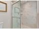 Bathroom with a glass-enclosed shower featuring marble-look tiling and a decorative art at 3003 W Roxboro Rd, Atlanta, GA 30324