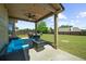 A covered patio with outdoor seating overlooks a spacious backyard with a well-maintained lawn and a wood fence at 5950 Hidden Ridge Ct, Cumming, GA 30028