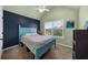 Bright bedroom featuring a light blue bed and sage green and navy accent wall at 5950 Hidden Ridge Ct, Cumming, GA 30028
