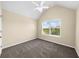 Neutral bedroom with a ceiling fan and a bright window looking out to green foliage at 5950 Hidden Ridge Ct, Cumming, GA 30028