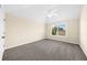 View of a neutral bedroom with carpet and a bright window, with a ceiling fan above at 5950 Hidden Ridge Ct, Cumming, GA 30028
