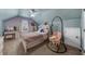 Cozy bedroom with sloped ceilings, featuring a unique hanging swing chair and a built-in headboard bookshelf at 5950 Hidden Ridge Ct, Cumming, GA 30028