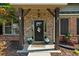 Inviting front porch with stone accents, decorative columns, and a welcoming entrance, enhanced by potted plants at 5950 Hidden Ridge Ct, Cumming, GA 30028