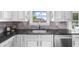 Modern kitchen featuring gray backsplash and black countertops, adding a touch of elegance at 5950 Hidden Ridge Ct, Cumming, GA 30028