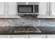 Modern kitchen with a stainless steel gas range top and tile backsplash at 5950 Hidden Ridge Ct, Cumming, GA 30028