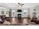 Spacious living room with a fireplace, dark hardwood floors, and lots of seating at 5950 Hidden Ridge Ct, Cumming, GA 30028