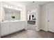 Light and bright bathroom with double sink vanity, large mirror and view into main bedroom at 6372 Rosetta Sw Dr, Atlanta, GA 30331