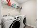 Convenient laundry room featuring modern washer and dryer units and storage shelving at 6372 Rosetta Sw Dr, Atlanta, GA 30331